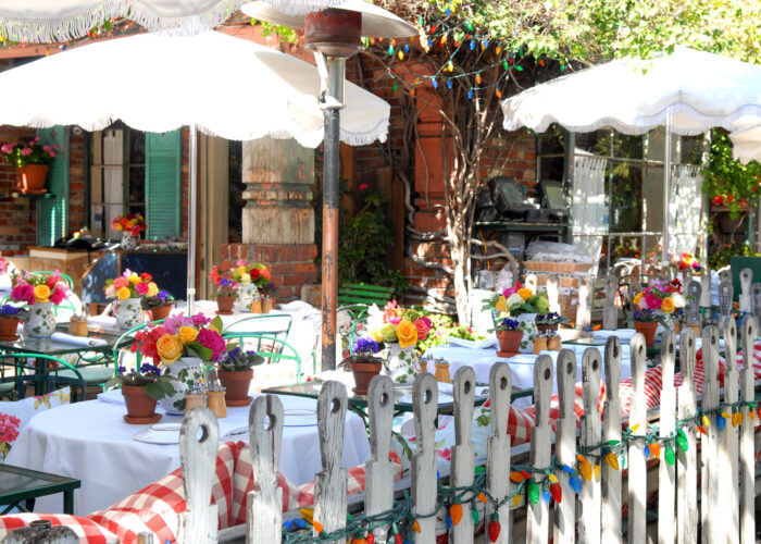 Quaint cafe with lots of colorful floral arrangements and cute white picket fence