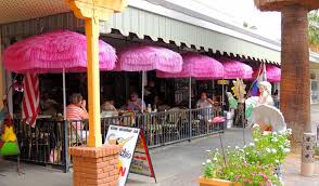 Exterior of building with tables,chairs and pink table umbrellas