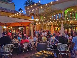 Outside tables and chairs with string lights overhead