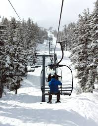 chairlifts with people with snow